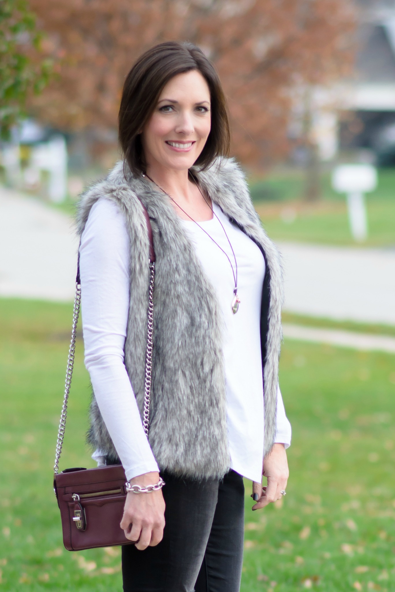 Winter Outfit Ideas: Fur Vest with Distressed Jeans and Long Sleeve Tee