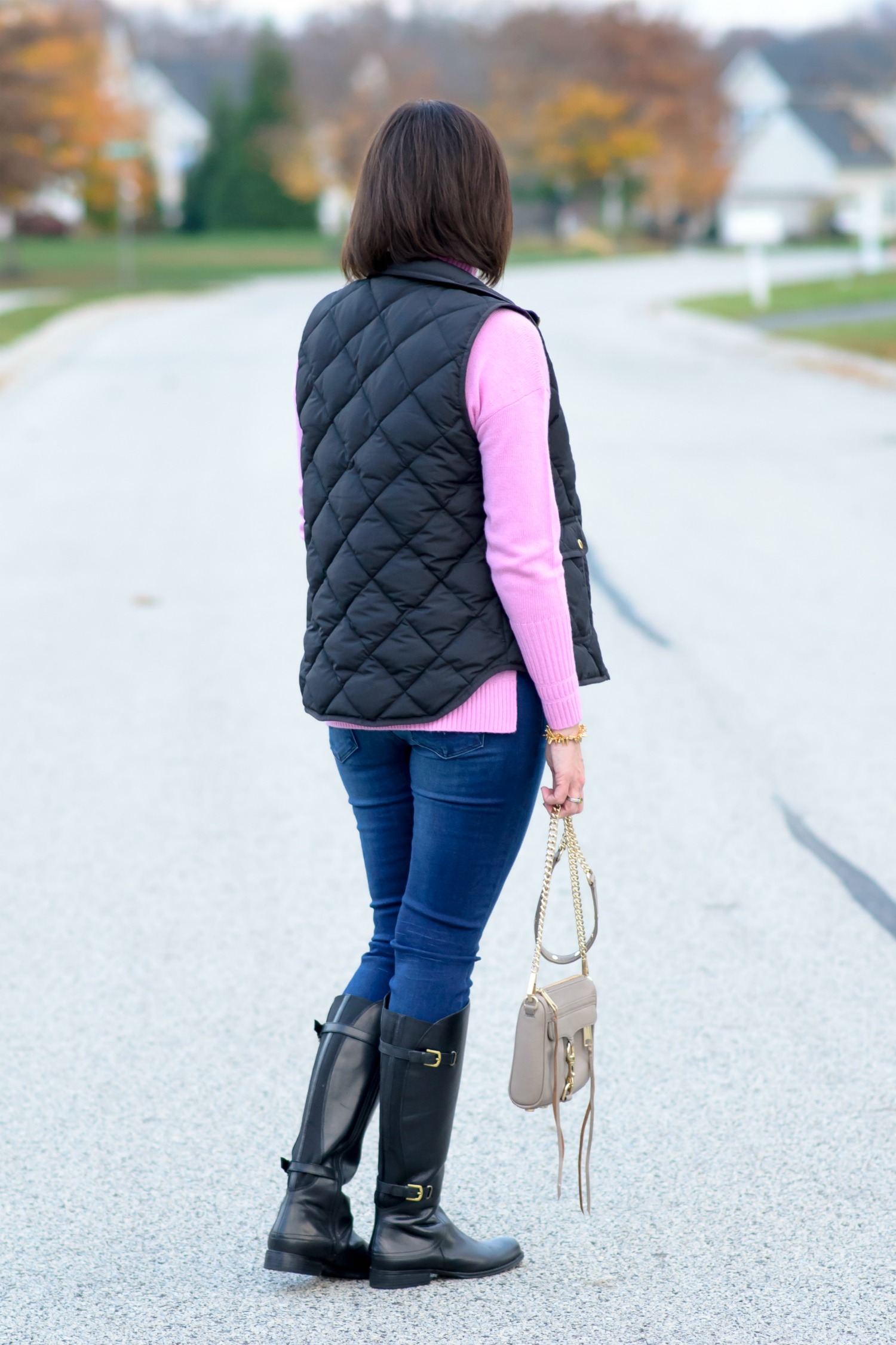 Casual Winter Outfit Ideas: Black Quilted Vest with Pink Wool Turtleneck, Skinny Jeans, and Black Riding Boots
