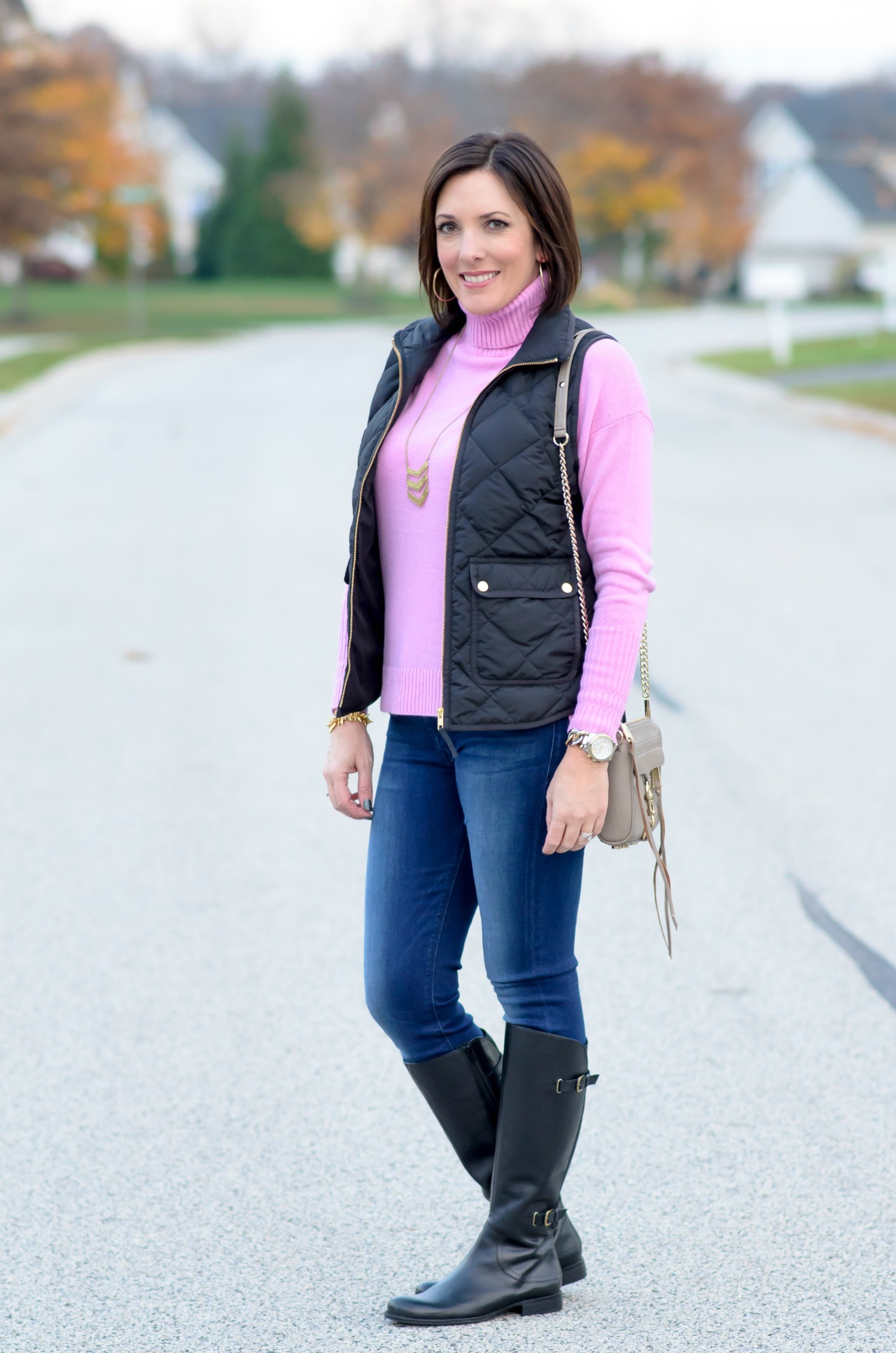 Casual Winter Outfit Ideas: Black Quilted Vest with Pink Wool Turtleneck, Skinny Jeans, and Black Riding Boots