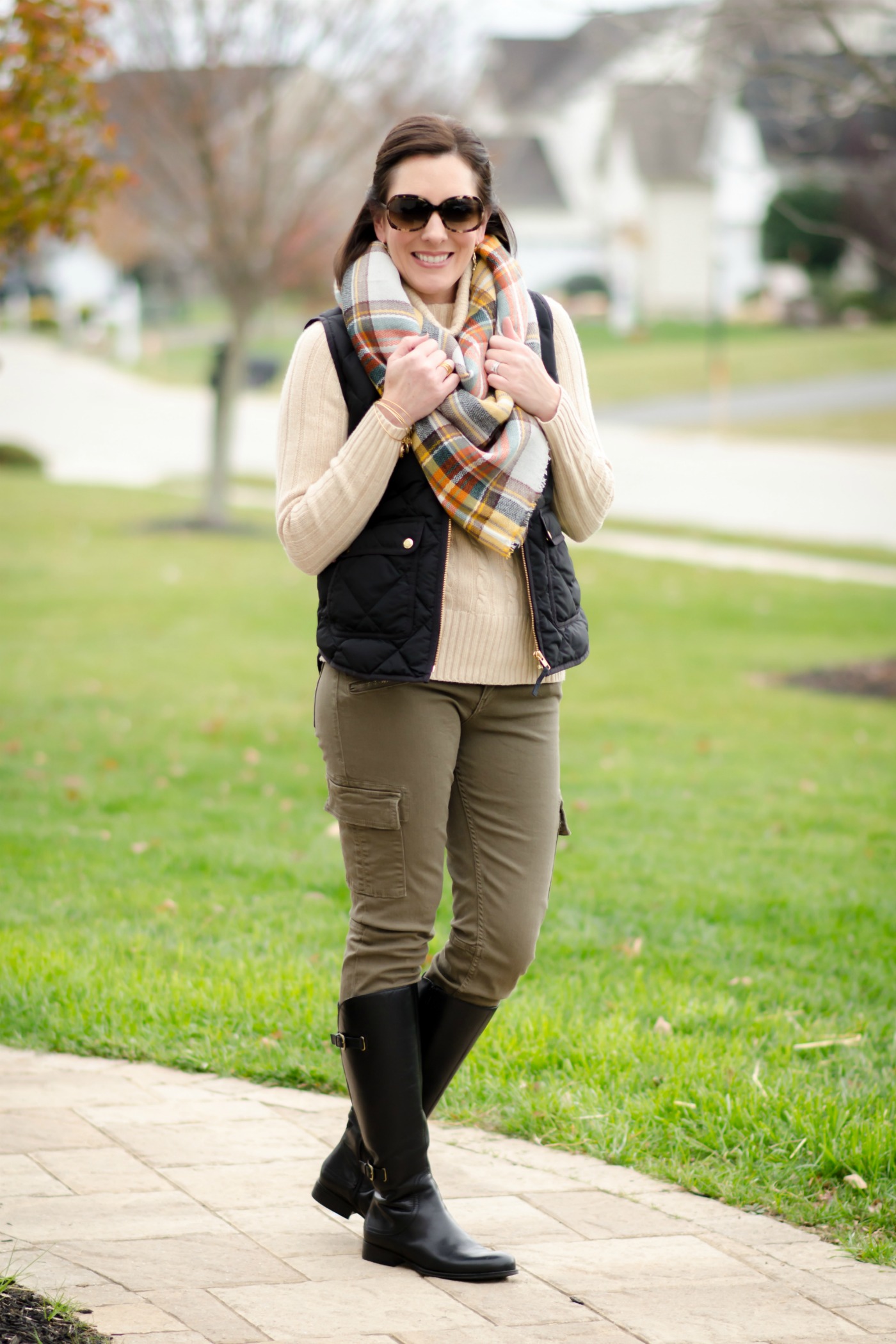 This is the perfect outfit for a chilly fall day spent outdoors: down vest, wool turtleneck, riding boots and blanket scarf.