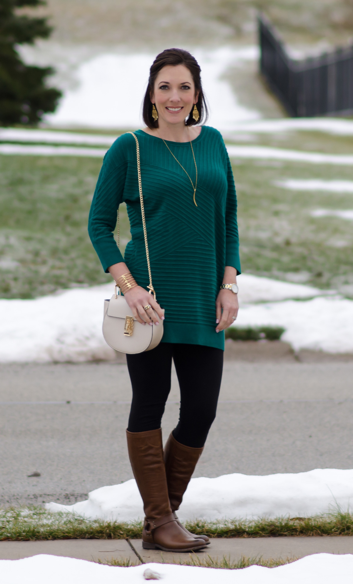 How to Wear Brown Boots with Black Based Outfits: Brown Riding Boots with Black Leggings and a Tunic Sweater in a rich Jewel Tone