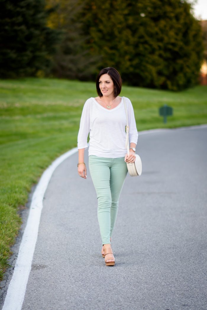 Mint skinnies, nude wedge sandals, and a crisp white top: the perfect outfit formula for spring! Tory Burch Lexington Wedge | Paige Verdugo Skinny Jeans | Tory Burch Serif T Saddle Bag in Ivory | Fashion Over 40