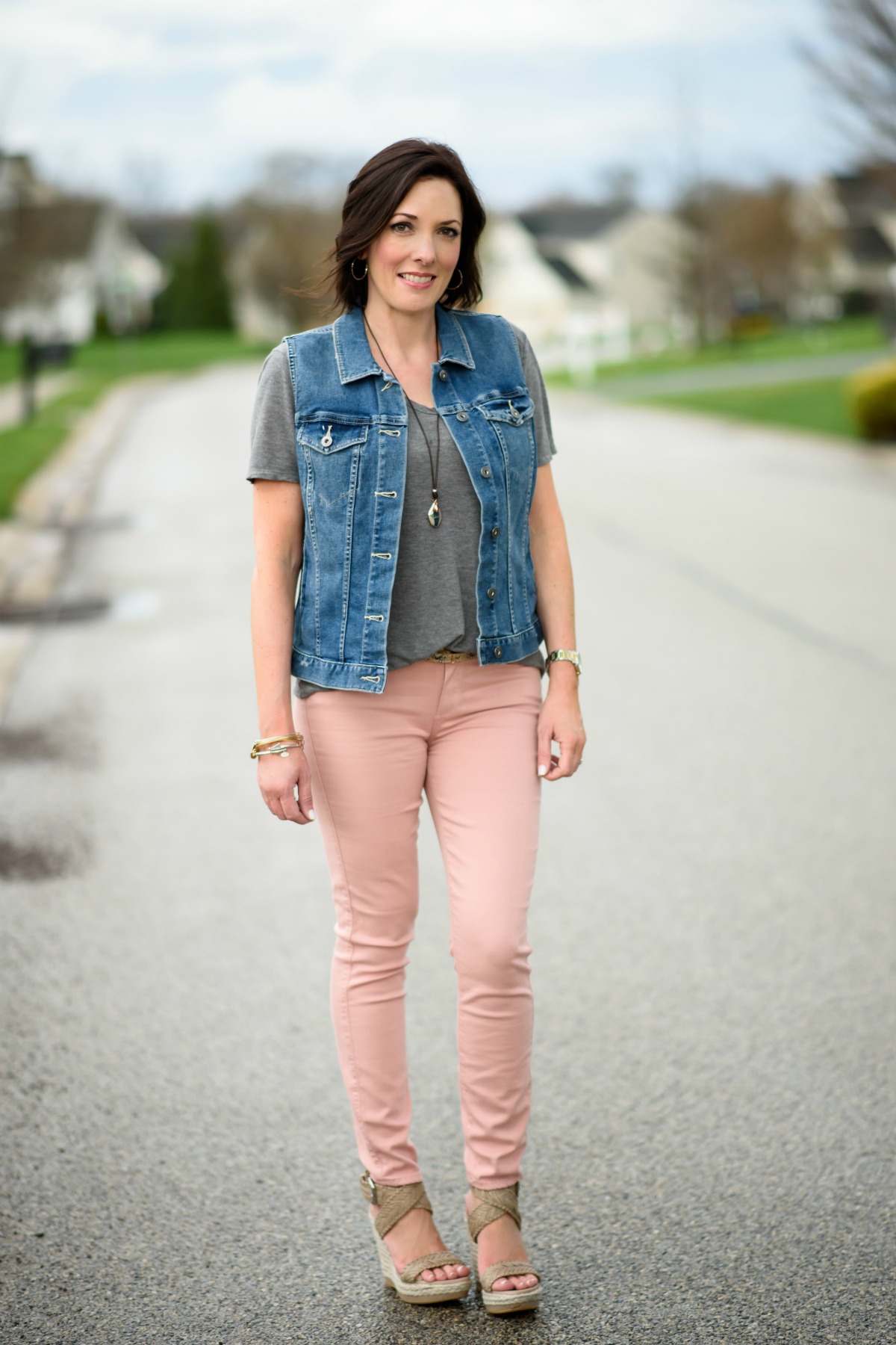 How To Style Pink Jeans: pink jeans, grey tee, denim vest, and wedge sandals