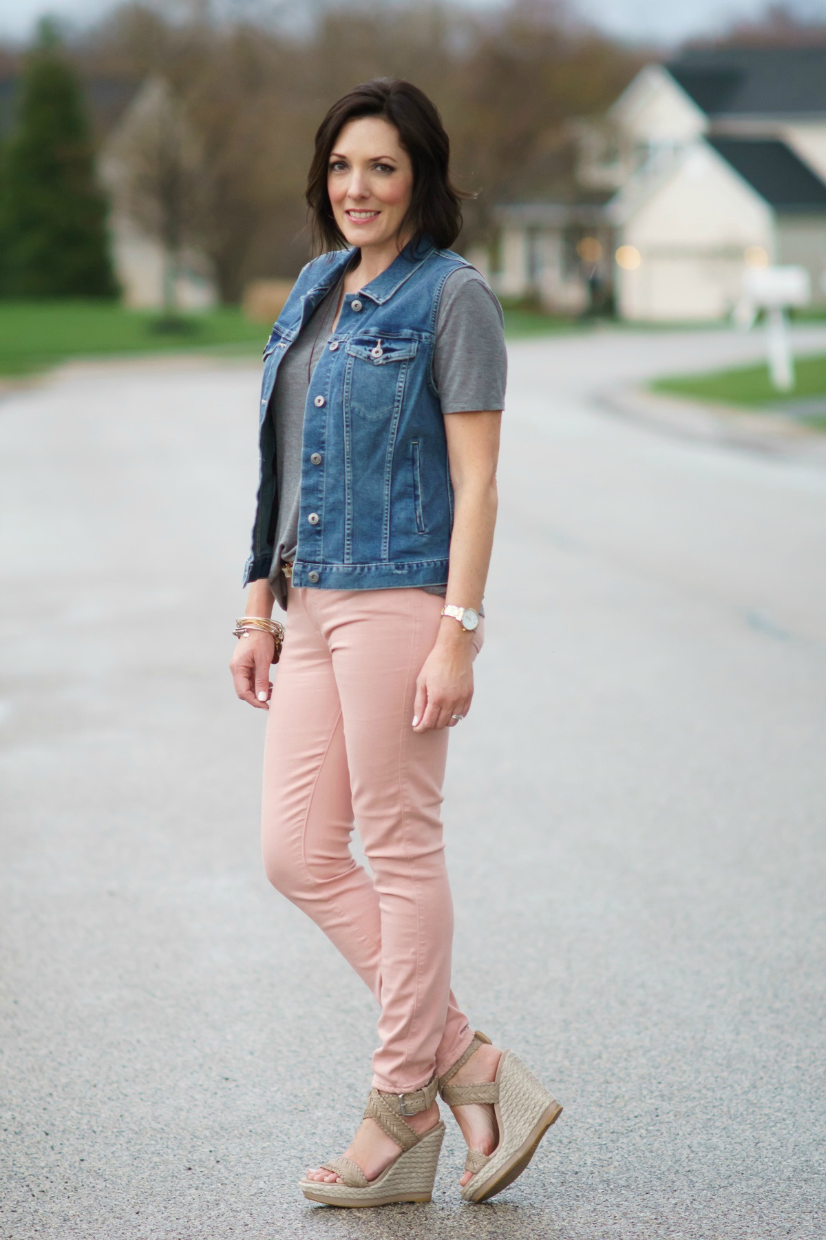 How To Style Pink Jeans: pink jeans, grey tee, denim vest, and wedge sandals