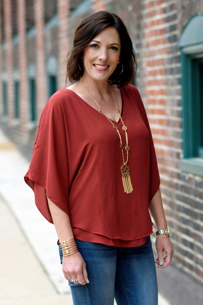 Jo-Lynne Shane wearing rust Kimono Blouse from White House Black Market with blue jeans and gold tassel necklace c/o QVC.