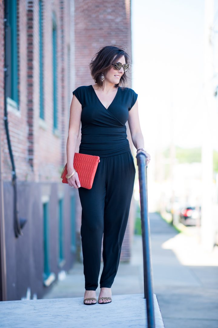How to Wear a Jumpsuit: An all black jumpsuit is stunning with leopard sandals and an orange clutch! Real fashion for real life.
