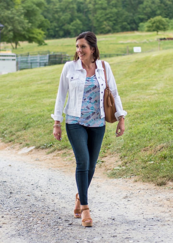 summer outfit for women over 40: printed drape neck shell with white denim jacket and crop jeans