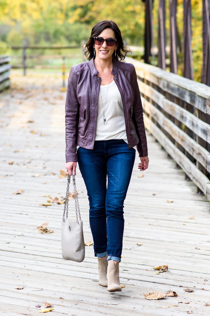 Fall Leather Jacket Outfit: Plum Leather Jacket with Beige Tee, AG Ankle Super Skinny Jeans, and Booties
