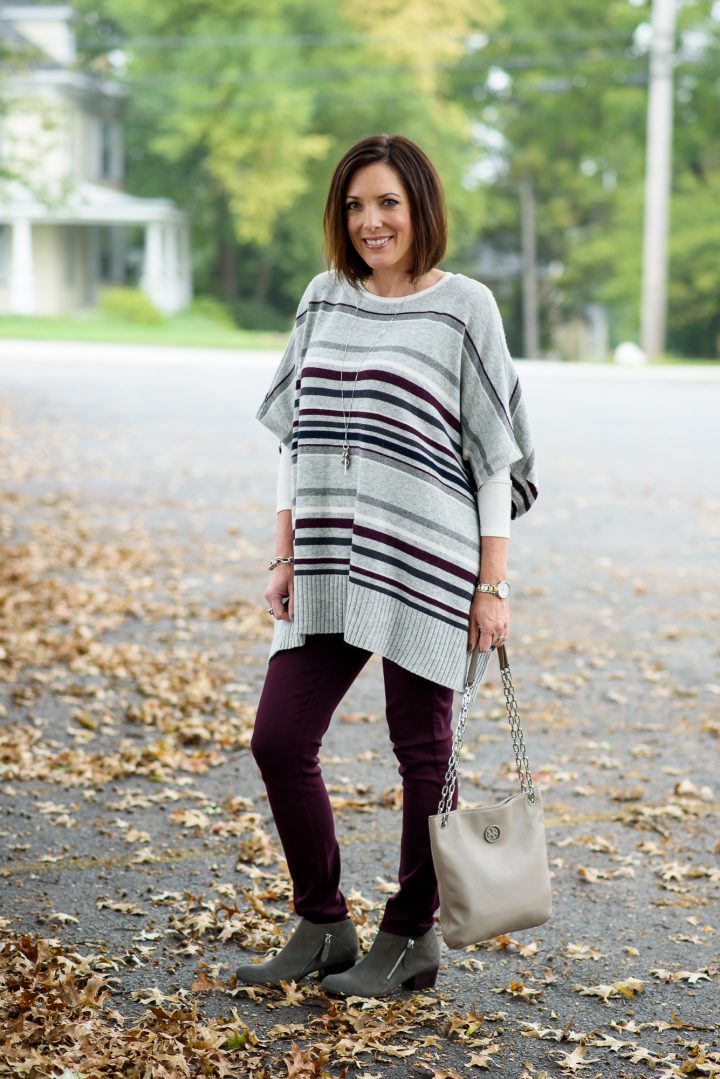 The perfect cozy fall casual look: striped poncho with aubergine skinnies and grey ankle boots!