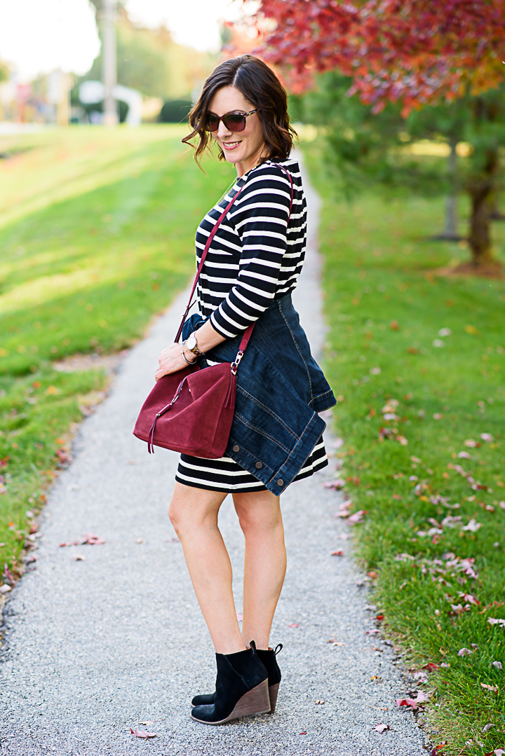 How to Wear a Black and White Striped Dress Outfit for Fall: with black ankle boots, denim jacket, and burgundy bucket bag