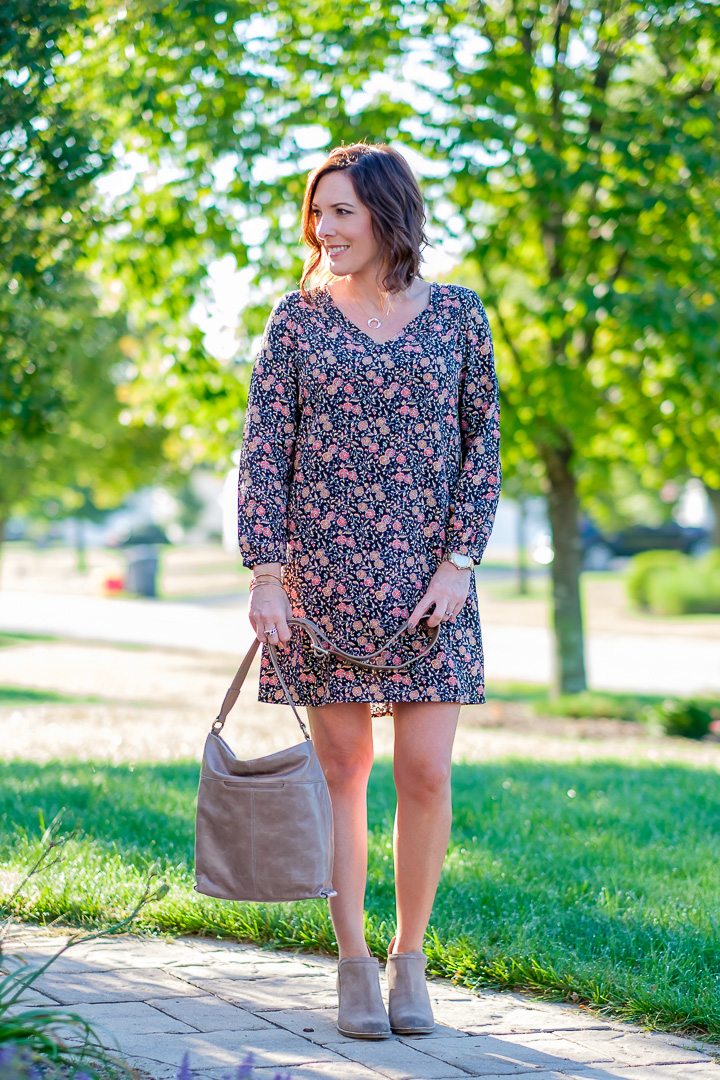 Fall fashion for women over 40: Jo-Lynne Shane wearing a shift dress in fall florals with taupe ankle boots and glazed leather crossbody. 