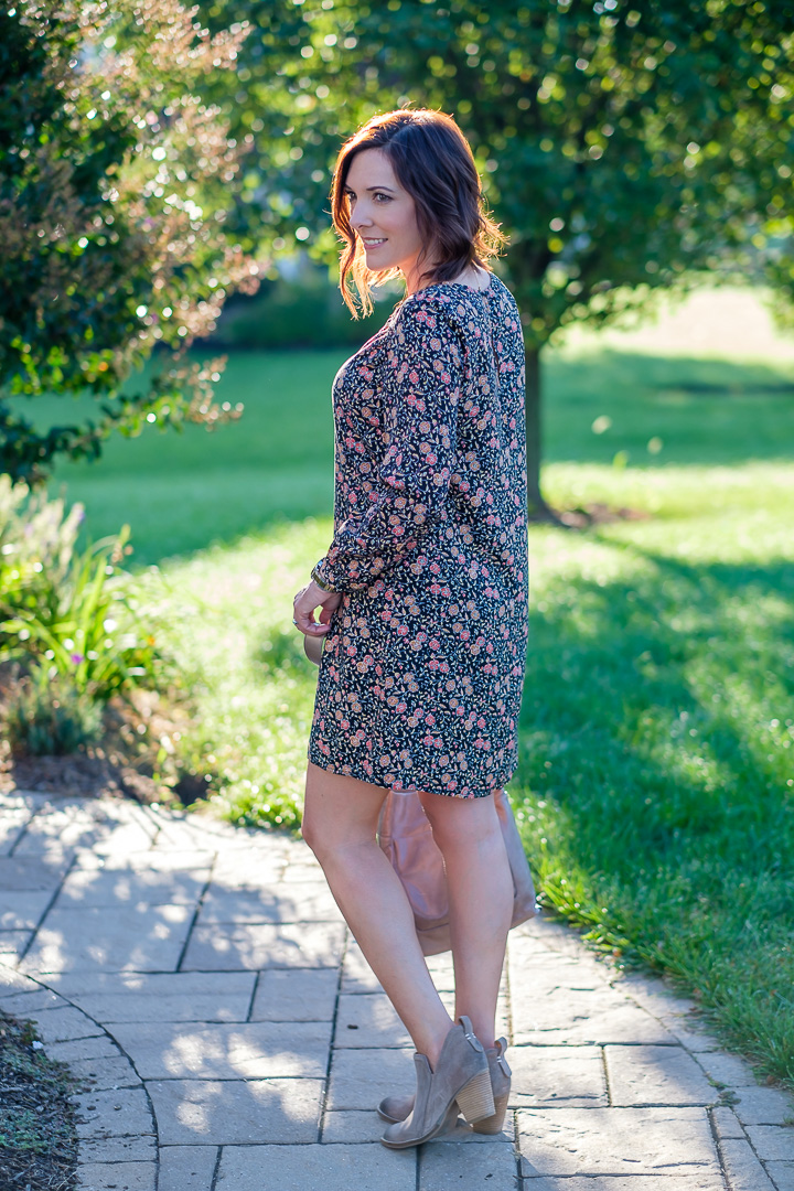Fall fashion for women over 40: Jo-Lynne Shane wearing a shift dress in fall florals with taupe ankle boots and glazed leather crossbody. 